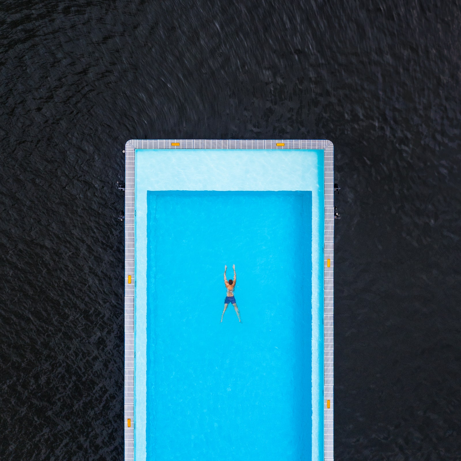 Aerial shot above a person swimming in the Badeschiff swimming pool River Spree Berlin Germany