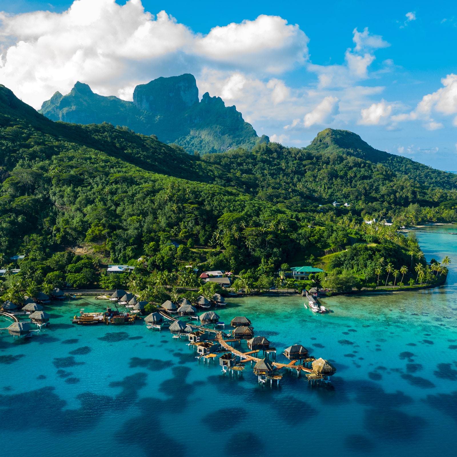 Bora Bora aerial drone video of travel vacation paradise with overwater bungalows luxury resort coral reef lagoon ocean...